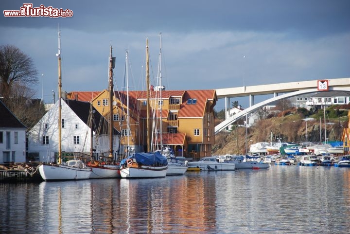 Immagine Ponte Risoy e scorcio della citta di Haugesund, Norvegia - Comune e città della contea di Rogaland in Norvegia, Haugesund venne fondata nel 1854 e fu grazie alla pesca dell'aringa se la gente iniziò a stabilirvisi. Con il trascorrere dei decenni l'industria e il commercio presero il sopravvento sulla pesca che era peraltro andata in crisi a causa della scomparsa delle aringhe. Oggi la città, con la chiusura dell'industria navale, sta gradualmente riaffermando la sua importanza come centro commerciale. In questo scorcio panoramico di Haugesund si distingue anche il ponte Risoy © alri / Shutterstock.com