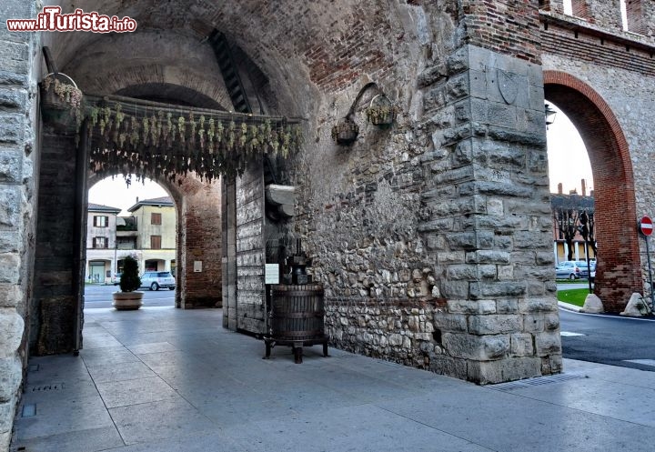 Immagine La Porta di Verona si apre nella mura di Soave, nella zona sud del Borgo. I grappoli appesi ad appassire ci ricordano la grande tradizione vinicola della zona