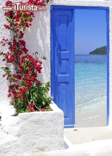 Immagine Un fotomontaggio che riassume la bellezza di Santorini: unaporta tipica diThira, ed il mare straordinario delle Cicladi in Grecia - © Yiannis Papadimitriou / Shutterstock.com