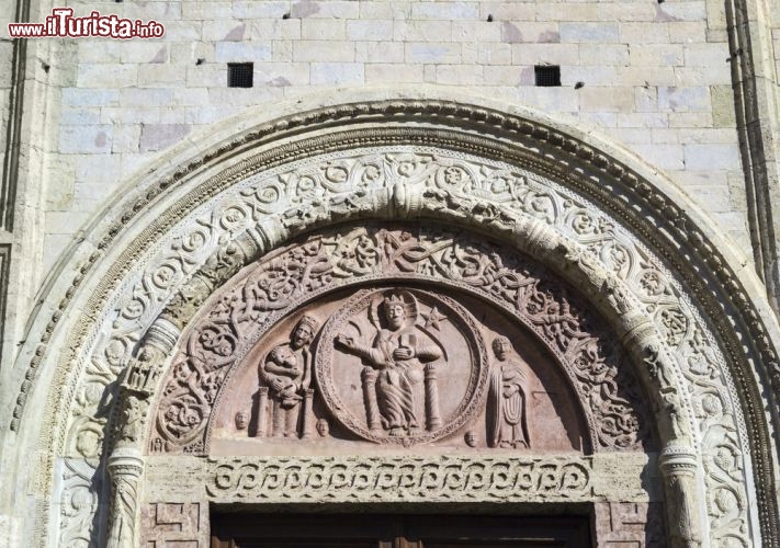 Immagine Il bel portale d'ingresso della Cattedrale di San Rufino. Duomo di Assisi, questo imponente edifico religioso sorge nell'omonima piazza, anticamente una terrazza, creata in epoca romana e probabilmente adibita in origine a foro della città. La sua facciata è uno degli esempi più interessanti dell'arte romanica umbra e si presenta con portali riccamente decorati. Quello centrale in particolare vanta un'ornamentazione fatta di figure allegoriche, animali, tralci e girali. La lunetta ospita il "Cristo in trono entro un clipeo tra il sole, la luna, la Madonna che allatta e San Rufino" - © Angelo Giampiccolo / Shutterstock.com