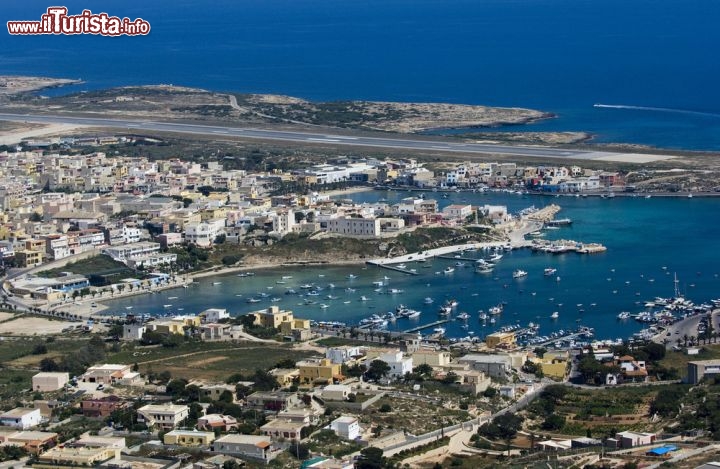 Immagine Il Porto e la città di di Lampedusa e sullo sfondo la pista dell'aeroporto che serve l'arcipelago delle isole Pelagie, a sud-est della Sicilia, nel cuore del mar Mediterraneo - © luigi nifosi / Shutterstock.com