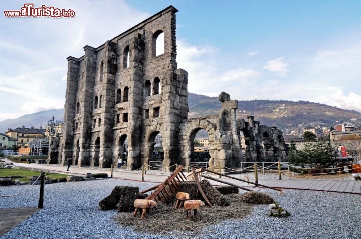 Immagine Presepe rustico al mercatino Natale di Aosta, sullo sfondo il Teatro Romano