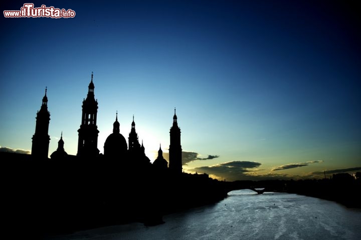 Immagine La Cattedrale di Saragozza (Aragona, Spagna) dedicata a Nuestra Señora del Pilar si staglia elegante contro il cielo del crepuscolo, lungo le sponde dell'Ebro - © Anna Mirabet / Shutterstock.com