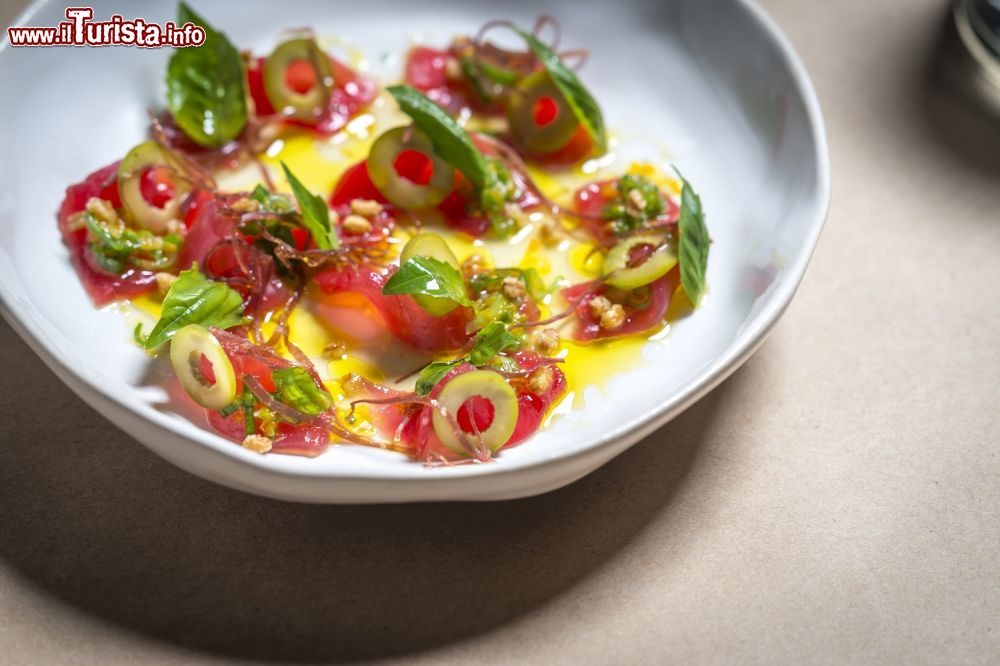 Immagine Un piatto di tonno crudo con olive e pomodori in un ristorante di New York, USA - © Noah Fecks