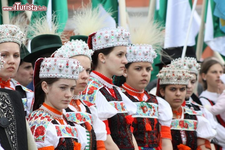 Immagine Ragazze con costume tradizionale rumeno, Cluj Napoca - In Romania esistono ben 112 costumi tipici fra cui spiccano due tipi di camicia femminile, quella  spiegazzata intorno al collo e quella dritta. Non mancano poi gilet di pelle di pecora ornati da fiori e cinte di lana decorate. Il costume popolare rumeno, sia per le donne che per gli uomini, è un intreccio di tradizione locale, possibilità economiche, clima e posizione geografica, un segno di identità etnica che da sempre accompagna questo popolo © Angyalosi Beata / Shutterstock.com