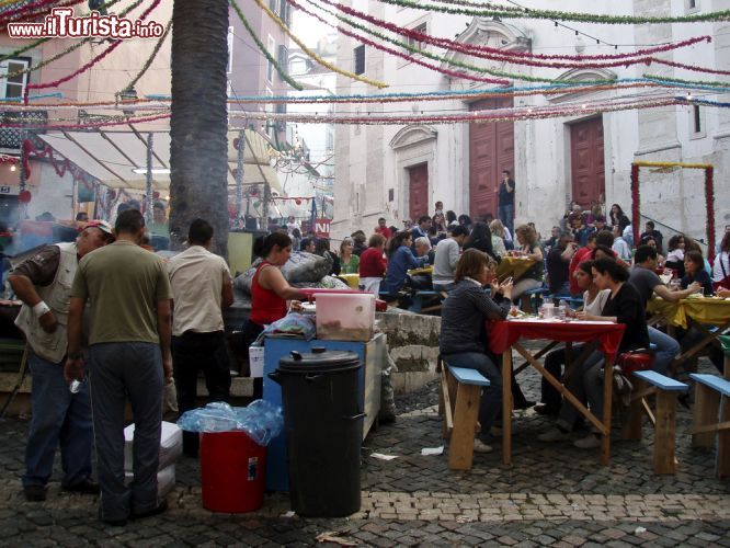 Immagine Gli stand gastronomici in una piazza di Lisbona in occasione della sagra di Sant'Antonio. Nel labirinto di stradine, scalinate sfalsate e piazzette minuscole dove le case sembrano quasi toccarsi l'un l'altra, i residenti del quartiere Alfama (nella zona sud della città), si trasformano in ristoratori grazie ad una particolare dispensa della municipalità di Lisbona - foto © Mapics / Shutterstock.com