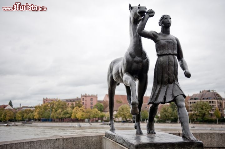 Immagine Particolare di scultura sul Mittlerebrucke di Basilea, Svizzera - Un'attenta armonia fra antico e moderno caratterizza questa città che si compone di tre distretti: la Città Vecchia (o Vieille Ville), la Grande Basilea (Grossbasel) e la Piccola Basilea (Kleinbasel). Sul Mittlerebrucke, che tradotto significa "ponte di mezzo", vi sono decorazioni e sculture che sembrano quasi impreziosire il passaggio di turisti e abitanti. Il panorama sul Reno e sul centro storico della città di cui si gode dal ponte è davvero suggestivo © Ventura / shutterstock.com