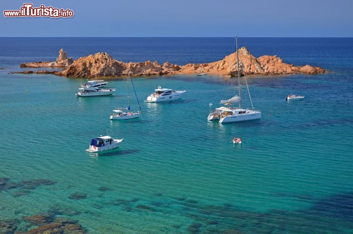 Immagine Minorca, Baleari: una serie di scogli che affiorano di fronte a Cala Pregonda forma una sorta di barriera che dà un sapore ancora più intimo e protetto alla spiaggetta. L'acqua trasparente e il fondale sabbioso attirano numerosi turisti - © Pawel Kazmierczak / Shutterstock.com