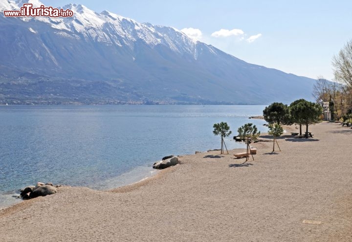 Immagine Spiaggia in primavera, Limone sul Garda - Grazie al clima mite caratterizzato anche dalla vicinanza con il lago, Limone accoglie i turisti con temperature decisamente gradevoli. Nei mesi primaverili, nonostante le piogge, la natura offre giornate riscaldate da un tiepido sole durante le quali ammirare la candida neve ancora presente sulle cime delle montagne © PeJo / Shutterstock.com