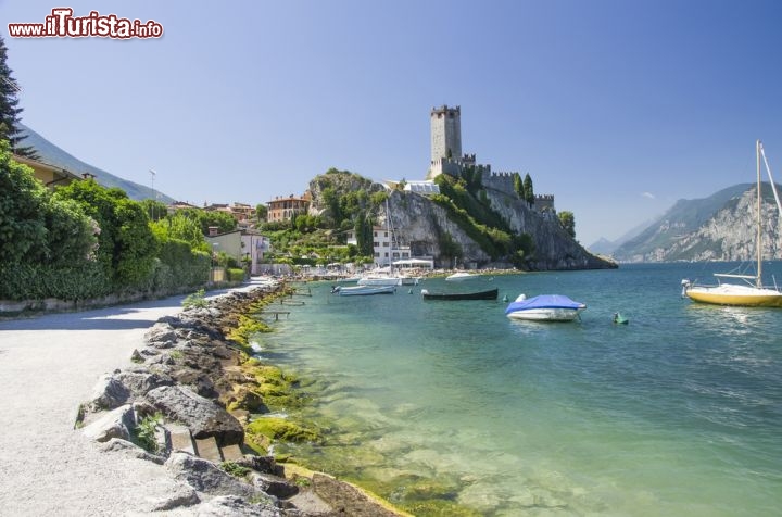 Immagine La spiaggia sul lungolago di Malcesine, Verona - Oltre ad essere perfetta location per un tuffo fra storia e arte, Malcesine è anche una delle mete favorite da chi è alla ricerca di attività sportive da praticare negli angoli più suggestivi del suo territorio. Le graziose spiagge che si affacciano sulle acque lacustri sono adatte a soste relax ma anche a windsurf ed escursioni in barca a vela © precinbe / Shutterstock.com