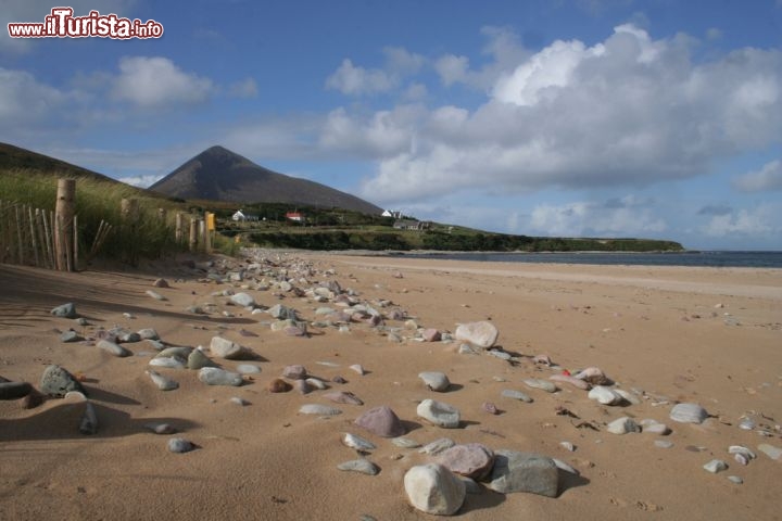 Immagine Scorcio della spiaggia di Dugort, Achill Island - Nella parte nord dell'isola sorge il pittoresco villaggio di Dugort famoso, fra l'altro, per aver ospitato il primo hotel costruito a Achill Island attorno al 1840. La spiaggia che si affaccia sull'Atlantico è una vasta distesa di finissima sabbia bianca in contrasto con il verde della vegetazione che sembra farle da cornice naturale © Gary Andrews / Shutterstock.com