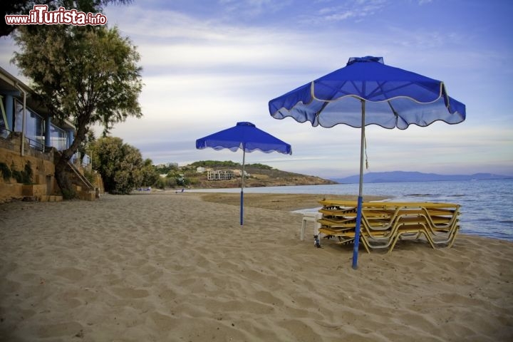 Immagine Isola di Chios, Grecia, Egeo nord-orientale: la spiaggia di Karfas è una delle più belle e famose dell'isola, situata a 7 km dalla città di Chios, con sabbia fine, acqua cristallina e ogni comfort si possa chiedere a un paradiso terrestre. Nell'immagine sta calando la sera, ma di giorno tanti ombrelloni si aprono per ospitare numerosi turisti. Bar, taverne e ristoranti tipici tutt'intorno alla spiaggia preparano dell'ottimo pesce fresco e altre ricette locali - © Kayla A / Shutterstock.com