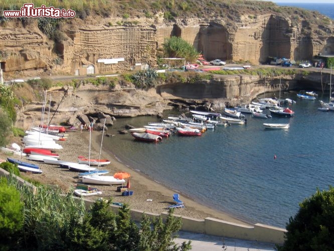 Immagine Una spiaggia di Ventotene, l'isola del Lazio, in provincia di Latina, che fa parte dell'arcipelago delle Pontine. Con circa 800 abitanti, a metà strada tra Ponza e Ischia, la piccola Ventotene è un'oasi di pace dalla natura selvaggia, in cui si alternano scogliere e spiagge di sabbia. Nell'immagine una caletta rocciosa gremita di barche   - © Roberto Aquilano / Shutterstock.com