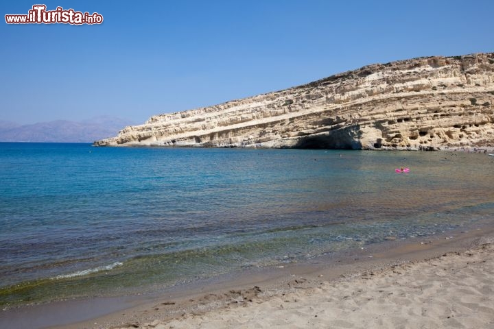 Immagine Spiaggia del villaggio di Matala a Heraklion, Creta - Una bella immagine della baia di sabbia e ciottoli abbracciata da scogliere di pietra porosa. Pittoresca e tranquilla, la spiaggia del villaggio di Matala  è bagnata da meravigliose acque turichesi © zz1969 / Shutterstock.com