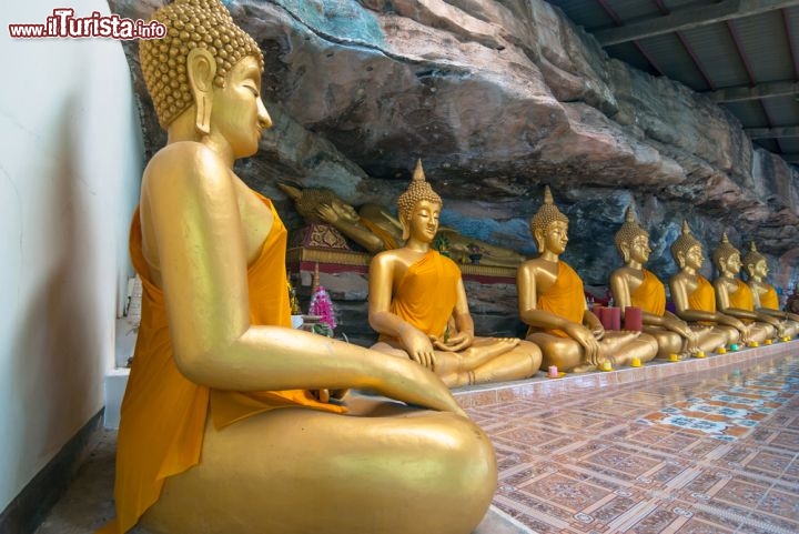 Immagine Statue al tempio Wat Tham Khuhasawan, Thailandia  - Costruito attorno ad uno sperone di roccia, il tempio Wat Tham Khuhasawan è uno dei più suggestivi luoghi di culto dedicati al buddhismo: al suo interno lo stupa ospita numerose statue votive davanti alle quali vengono accese candele di cera in segno di preghiera © TZIDO SUN / Shutterstock.com