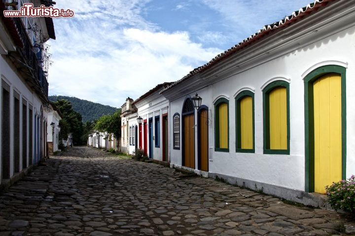Immagine Una strada tipica del centro coloniale di Paraty, in Brasile, non distante da Rio de Janeiro. La città si sviluppò moltissimo in epoca barocca, quando il suo porto divenne il secondo, per importanza di tutta la colonia portoghese. Lo splendore di Paraty derivava dal commercio dell'oro, che veniva estratto nel Minas Gerais, che poi veniva qui imbarcato. La fine del prezioso minerale determinò la decadenza di Parati, che però  nell'ultimo secolo ha convertito le sue industrie per la prduzione di acquavite, una delle migliori del Brasile - © Luiz Rocha / Shutterstock.com
