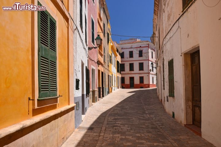 Immagine Cittadella di Minorca è il secondo centro urbano dell'isola per popolazione e importanza, con 28.000 abitanti e un importante porto. Nella foto una stradina caratteristica: le case colorate creano un contrasto vivace con l'azzurro del cielo - © Pawel Kazmierczak / Shutterstock.com