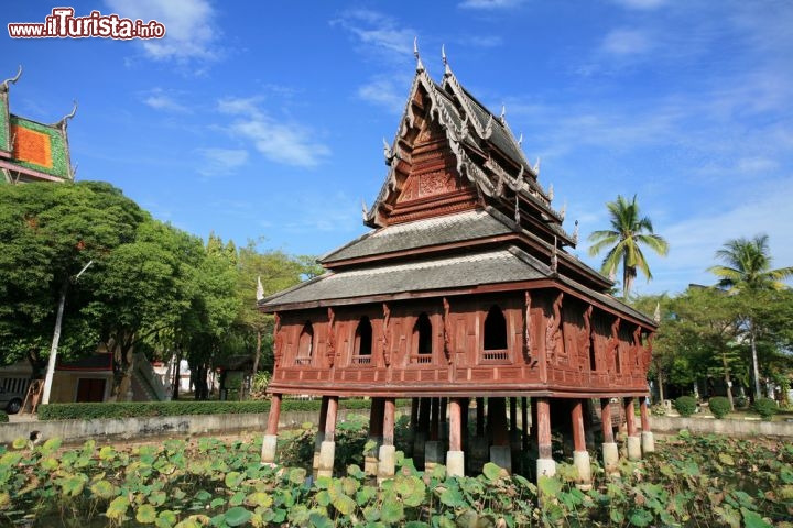 Immagine Panorama sul Thung Si Meuang a Ubon Ratchathani - Una grande vasca d'acqua impreziosita da fiori di loto ospita al suo centro una caratteristica stupa costruita sulla base di una palafitta. Decisamente sobria, rispetto a molti altri edifici religiosi, la facciata del tempio che ha motivi ornamentali intagliati nel legno © Blanscape / Shutterstock.com