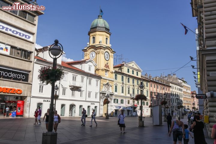 Immagine La Torre dell'Orologio a Rijeka, Croazia - Interessante meta turistica affacciata sulle acque blu della Baia di Kvarner, sul Mare Adriatico, Rijeka (conosciuta dagli italiani come Fiume) unisce alla perfezione monumenti storici e artistici a bellezze naturali. Fra le visite da non perdere nella bella località croata vi è la Torre dell'Orologio (o Torre Civica), splendido edificio asburgico sul cui portale si possono ammirare stemmi storici, l'aquila e i busti degli imperatori Leopoldo I e Carlo VI. Dal grande portale si raggiunge il cuore del centro storico e l'antico Castrum © Grzegorz Petrykowski / Shutterstock.com