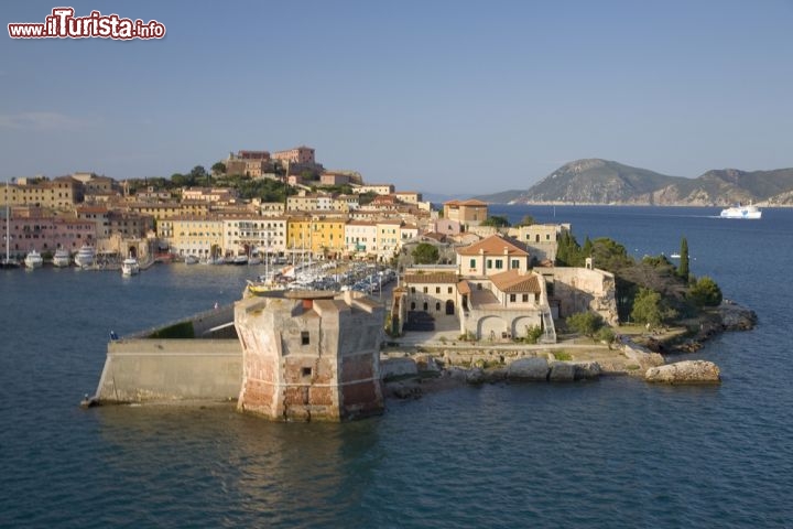 Immagine Portoferraio, Isola d'Elba: la Torre della Linguella, o Torre del Martello, è la sentinella costiera che accoglie i turisti in arrivo nella rada. Eretta nel Cinquecento su un preesistente edificio romano, fu commissionata dai Medici per proteggere il porto da eventuali nemici in arrivo e continuò a vegliare il mare per un paio di secoli, finché non fu trasformata in carcere. Abbandonata a fine Ottocento, la torre fu restaurata negli anni Settanta del secolo scorso e oggi ospita mostre e esposizioni - © spirit of america / Shutterstock.com