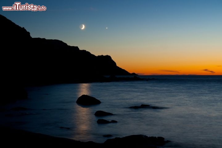 Immagine Tramonto nella Spiaggia di Porticciolo, a nord di Alghero, in Sardegna. Incastonata all'interno della Cala Viola, lungo quella che viene chiamata Riviera del Corallo, questa spiaggetta sabbiosa abbracciata dagli scogli è romantica e avventurosa allo stesso tempo, dominata da una torre aragonese - © Oleksiy Drachenko / Shutterstock.com