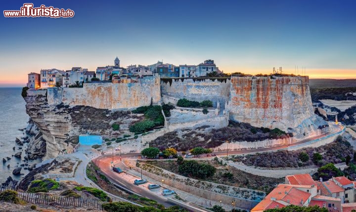 Immagine Tramonto a Bonifacio, nel Sud della Corsica, sullo stretto delle Bocche di Bonifacio che separa l'isola dalla Sardegna. Al calar del sole la luce rosata rende ancor più pittoresco l'abitato, dove le abitazioni si fondono con le scogliere - © infografick / Shutterstock.com