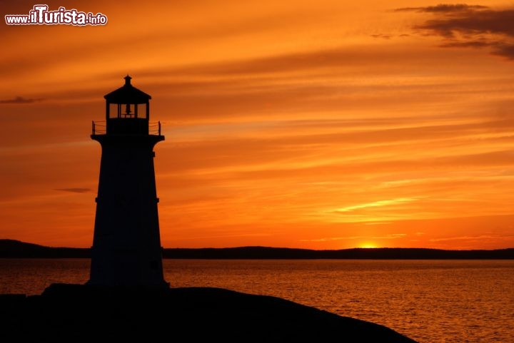 Immagine Tramonto a Peggy's Cove, Canada, sulla sponda orientale della St. Margarets Bay. In primo piano la sagoma di uno dei fari che costellano la Lighthouse Route (appunto "la Strada dei Fari"), itinerario che tocca vari borghi lungo la costa canadese e una ventina di vecchi fari - © matthewsinger / Shutterstock.com