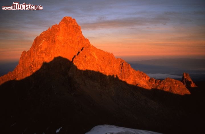 Immagine Tramonto spettacolare sul Monte Kenya. Siamo in Africa orientale, lungo la famosa Rift Valley. Il Kenya è un vulcano antico, probabilmente formatosi circa 3 milioni di anni fa. Quando era pienamente attivo doveva raggiungere una altezza di circa 7.000 metri, rendendolo la montagna più alta del pianeta, al di fuori dell'Himalaya - © Jiri Haureljuk / Shutterstock.com