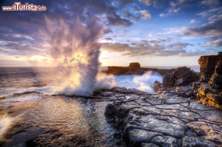 Immagine Un "blowhole" al tramonto lungo la costa dell'isola di Réunion (Isole Mascarene, Francia). Per i geologi un “blowhole” è uno sfiatatoio di grotte marine che può originare esplosioni d'acqua in superificie: è uno spettacolo affascinante ma pericoloso, da ammirare a distanza, perché alla fuoriuscita dell'acqua segue un risucchio d'aria molto potente, in grado di catturare una persona - © infografick / Shutterstock.com