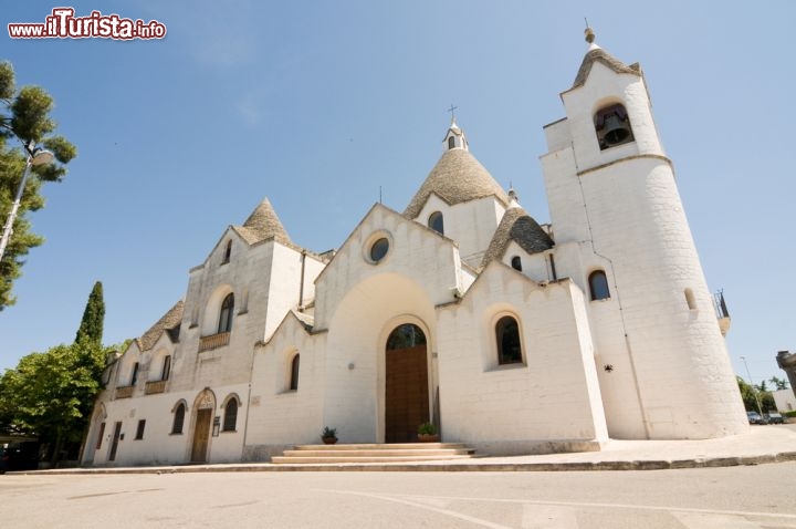 Immagine Una chiesa tra i Trulli di Alberobello - ©kwork75 / Shutterstock.com