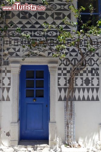 Immagine Una tipica casa sull'isola di Chio, in Grecia, nel Mar Egeo orientale. Passeggiando tra il frinire di cicale e il profumo di macchia mediterranea noterete tante casette bianche: baciate dal sole diventano abbaglianti, a volte hanno decorazioni di sasso e le porte e le finestre sono rigorosamente blu - © fivepointsix / Shutterstock.com