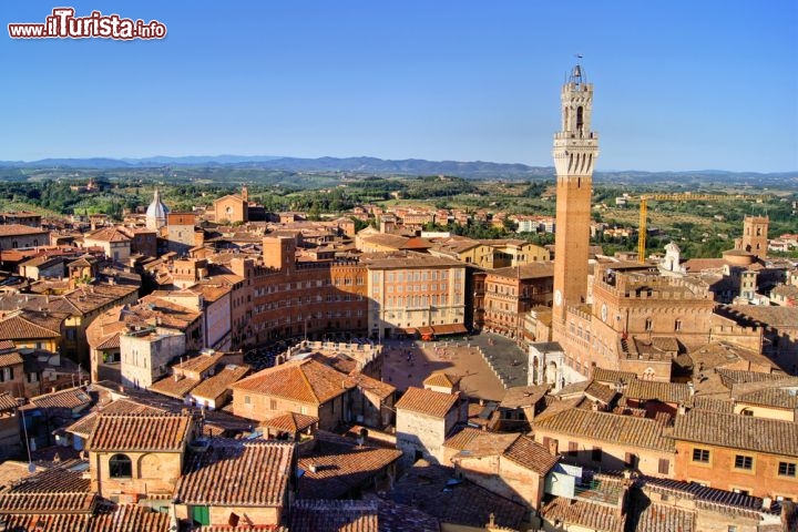 Immagine Veduta aerea di Siena (Toscana), con la celebre Piazza del Campo e l'alta Torre del Mangia che affianca il Palazzo Comunale. Intorno a Piazza del Campo, dall'originalissima forma a conchiglia, gli edifici si dispongono ad anfiteatro e danno vita a un ambiente molto scenografico - © JeniFoto / Shutterstock.com