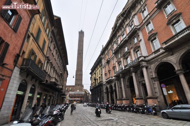 Immagine Via Rizzoli a Bologna, in fondo il profilo della Torre Asinelli, la più alta delle torri pendenti, Emilia Romagna. La torre si innalza per 97,20 metri e pende verso ovest per circa 2,32 metri. Per raggiungere la sommità bisogna salire 498 gradini.