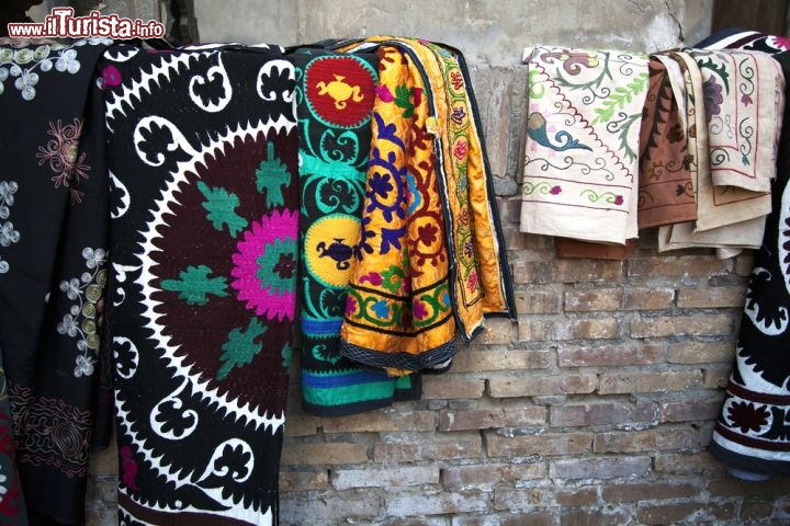 Immagine Via del centro di Bukhara in Uzbekistan, con esposti dei tessuti artigianali  - © Enrico01 / Shutterstock.com