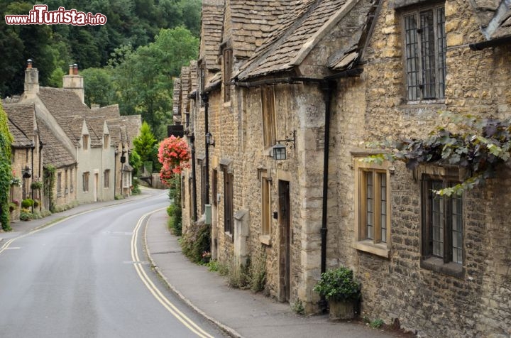 Immagine Una via del borgo di Castle Combe, Inghilterra - Con le case dai muri in sasso e i tetti in pietra naturale, così belle da essere considerate monumenti storici e preservate con regolamenti severi, Castle Combe affascina da sempre turisti e visitatori che si avventurano alla sua scoperta percorrendo la strada che corre da Market Cross lungo il corso del fiume Bybrooke © iPics / Shutterstock.com