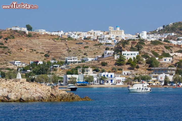 Immagine Il porto di Psathì, sull'isola di Kimols (Cicladi, Grecia), sorge a un chilometro dal villaggio principale di Choriò. Una schiera di casette bianche con le finestre blu, incastonate tra le rocce e la macchia, accoglie le navi in arrivo dal Pireo, da Lavrio e da Milos - © Lefteris Papaulakis / Shutterstock.com