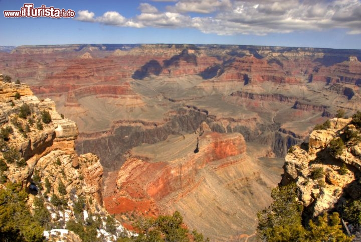 Immagine Vista dell'impressionante Grand Canyon come si può ammirare dall'inizo del famoso sentiero Bright Angel Trail, che da bordo del  South Rim, si getta fino ad arrivare in fondo al canyon, circa 2 km più in basso. Chi pensa di compiere l'escursione ricordiamo che per risalire dal fondo del canyon si possono impiegare circa 6-7 ore di tempo, e quindi bisogna avere una buona dotazione di acqua, come minimo 2,5 litri per persona. E' anche da considerare che tra cima e base del canyon possono esserci dai 15 ai 20 °C di differenza, con le temperature più elevate in fondo - © stanmford / Shutterstock.com