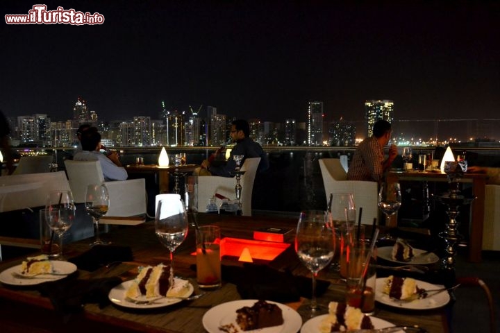 Immagine La vita notturna ad Abu Dhabi si svolge soprattutto nei locali e nei ristoranti più famosi; in questa foto siamo a cena su Al Maryah Island, nella terrazza del Rosewood Hotel, davanti alla suggestiva veduta della skyline della capitale.