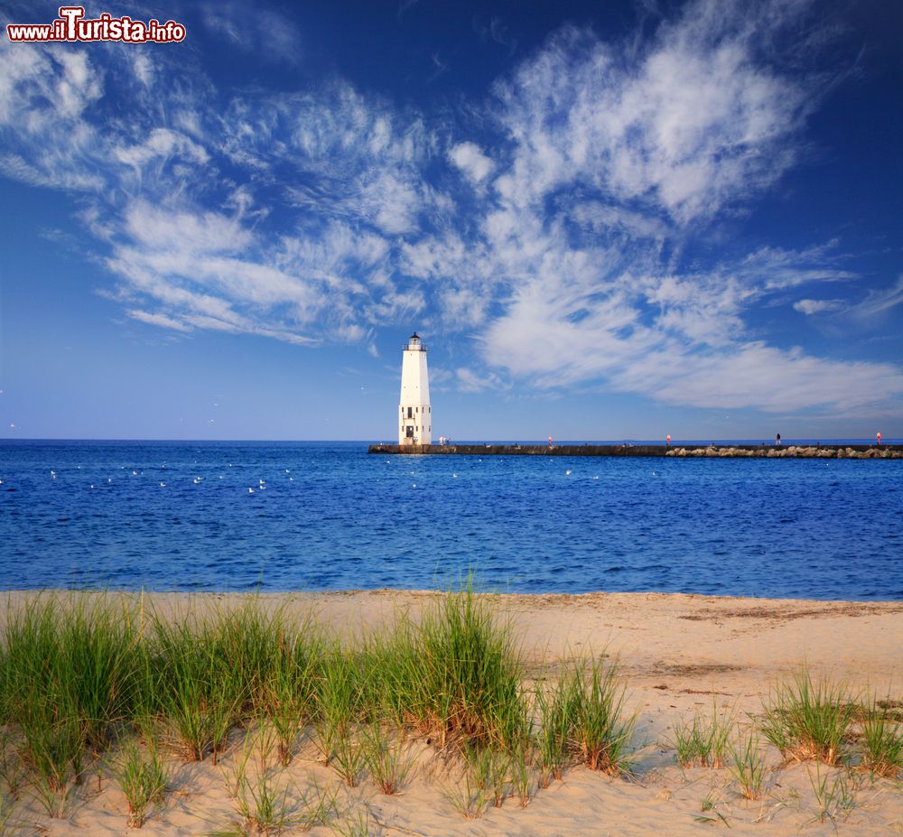 Immagine L'acqua blu del lago Michigan e la spiaggia di sabbia nei pressi del faro di Frankfort, Stati Uniti d'America, in una mattina d'estate.