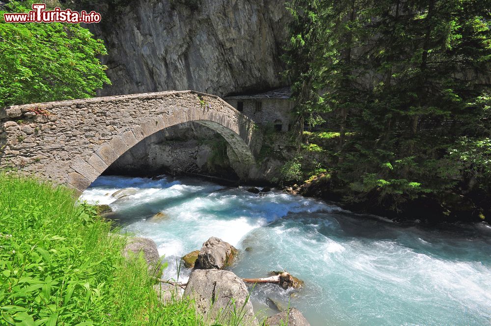 Immagine L'acqua limpida di un torrente di montagna e un antico ponte in pietra a Pré-Saint-Didier, Valle d'Aosta. Siamo nella Valdigne, l'alta valle della Dora Baltea.
