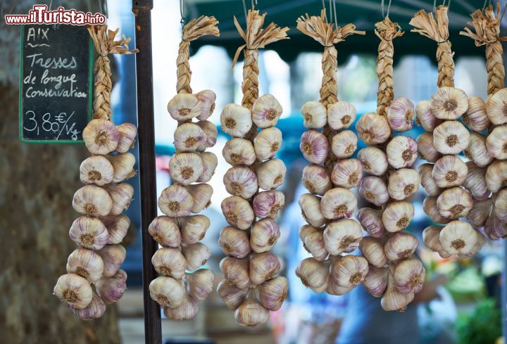 Immagine Aglio in vendita al mercato di Aix-en-Provence, France - Trecce di aglio dalle sfumature violacee esposte nelle bancarelle del mercato ortofrutticolo della città provenzale © Nikolay Dimitrov - ecobo / Shutterstock.com