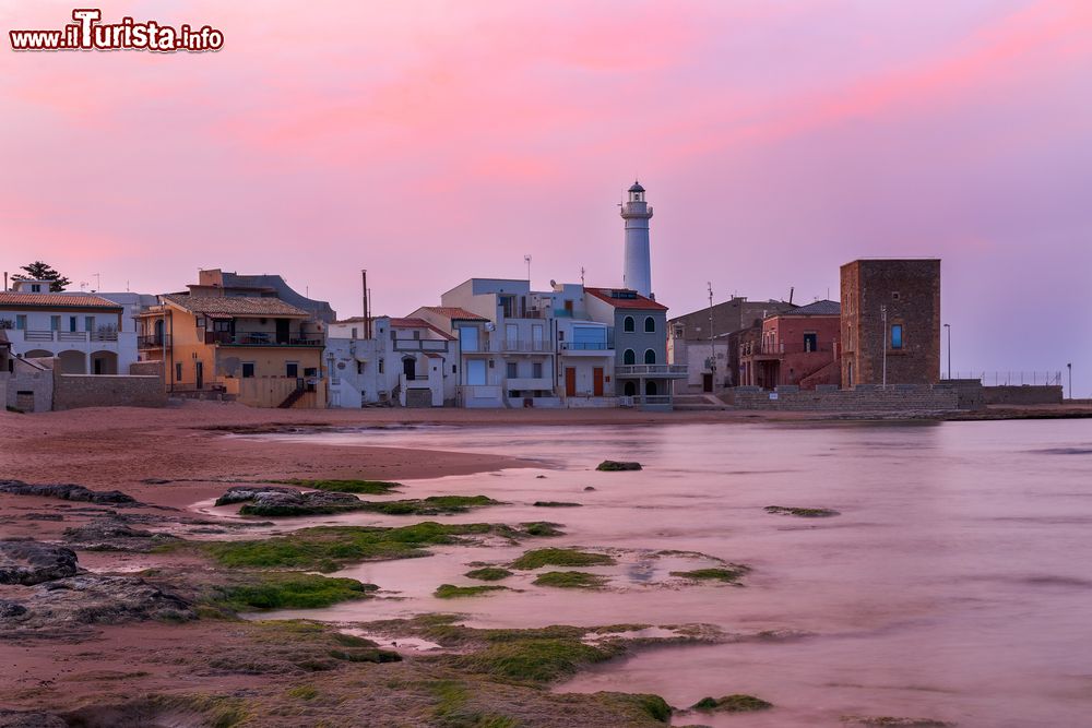 Immagine Alba a Punta Secca, dove si trova la Casa di Montalbano: sullo sfondo il faro e Torre Scalambri. Siamo a Santa Croce Camerina in Sicilia.