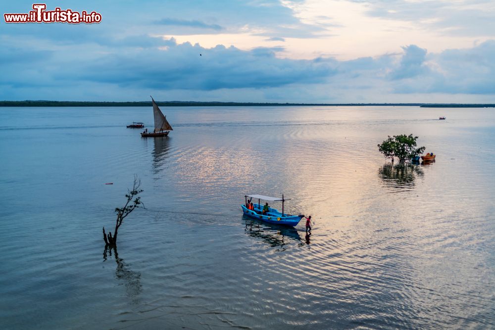 Immagine Alba su Lamu Bay, Kenya, Africa. Barche e dhow si muovono lentamente nelle acque dell'Oceano Indiano alle luci del primo mattino.