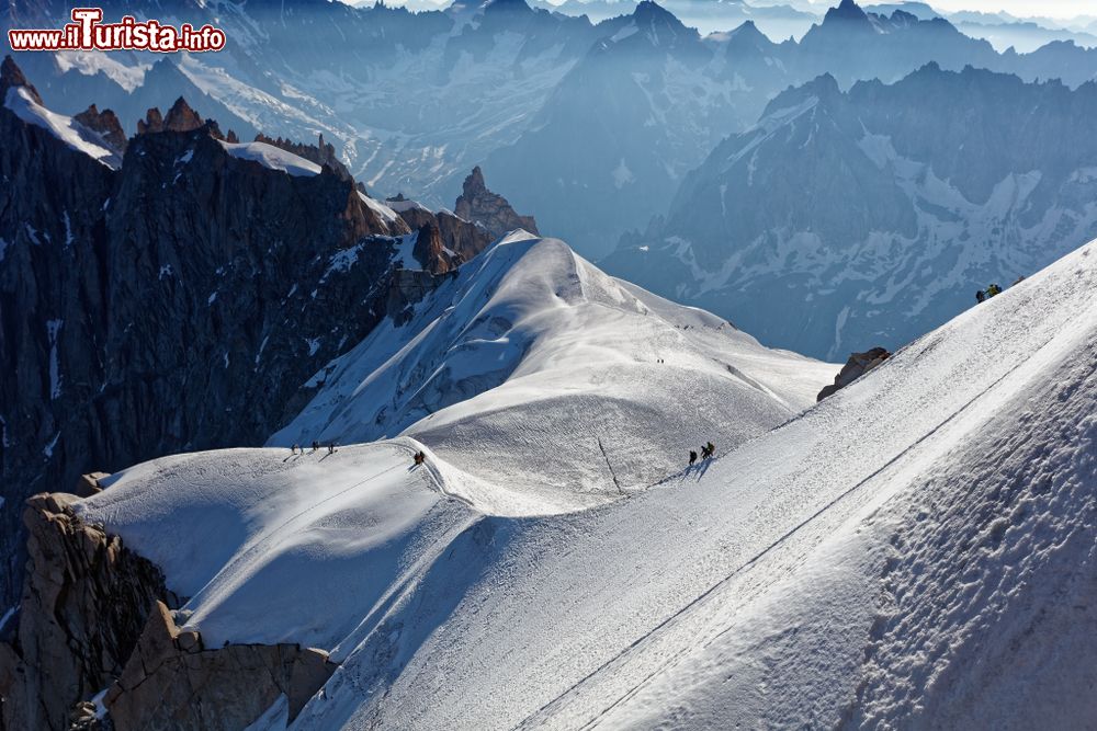 Immagine Alpinisti sui monti innevati di Chamonix, Francia: in discesa dalla funivia dell'Aiguille du Midi verso il ghiacciaio.