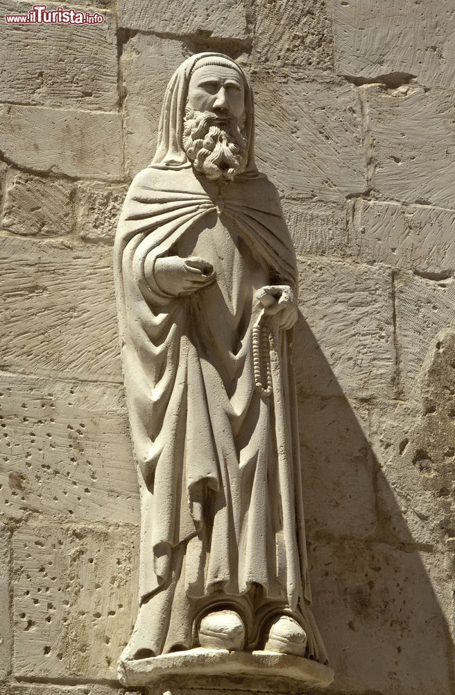 Immagine L'antica statua di un religioso sulla facciata della chiesa di Santa Maria Maggiore a Caramanico Terme, Abruzzo, Italia. La Collegiata di Santa Maria Maggiore si presenta con esterni gotici impreziositi da sculture e raffigurazioni sacre.