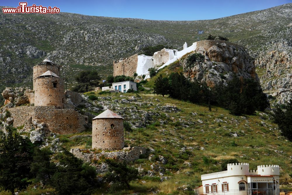 Immagine Antico castello di Chrysocheria sull'isola di Kalymnos, Grecia. La fortezza si trova a metà strada fra Hora e Pothia. In primo piano, tre mulini a vento visti dal porto dell'isola.