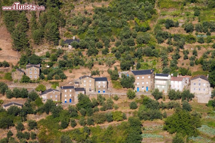 Immagine Antico villaggio di Piodao, Portogallo - Nella regione delle Beiras, nel Portogallo centro settentrionale, sorge il borgo storico di Piodao che per la forma armoniosa delle sue case, l'una a fianco dell'altra come in un anfiteatro, sembra uscito da un presepe. Celebre per i suoi edifici in pietra di granito e scisto, è annoverata fra i paesi storici protetti e di interesse pubblico tanto da essersi aggiudicata nel corso degli anni ottanta il "gallo d'argento" assegnato ai villaggi più tipici del Portogallo © cristovao / Shutterstock.com