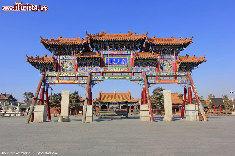 Immagine Architettura al Dazhao Lamasery di Hohhot, capitale della Mongolia Interna. Questo arco, decorato da scritte e fantasie floreali e con figure di animali, è sormontato dai tipici tetti dei monumenti buddhisti - © chinahbzyg / Shutterstock.com