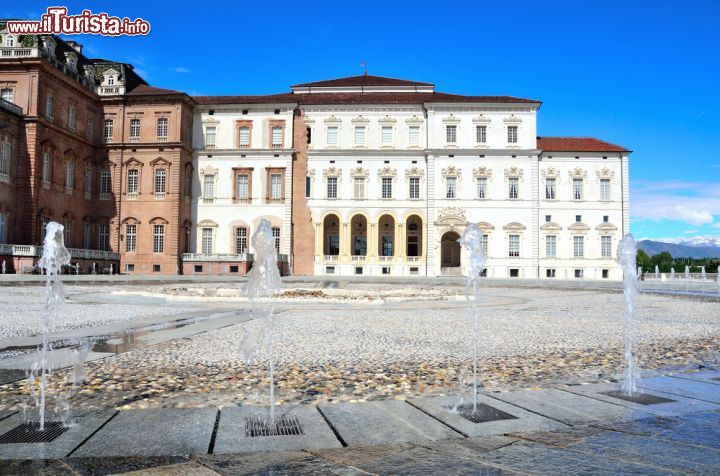 Immagine Scorcio da cui poter ammirare l'architettura del Palazzo di Venaria Reale, Torino (Piemonte) - Ci sono alcune case di Kork (Irlanda) che sono incapaci di rimanere statiche, per via dei loro colori affiancati che sono l'uno diverso dall'altro. Qui, lo spirito della meraviglia è un po' lo stesso, ma rafforzato da dimensioni molto più generose. L'architettura che si respira al Palazzo di Venaria Reale si evince dappertutto, merito anche delle fontane così accessibili da risultare sfiziose e leggere. Nelle giornate diurne poi, quando il cielo è terso come nell'immagine, i colori si tingono di una luce esterna che automaticamente diventa interna e si posa nell'animo di ogni visitatore - © maudanros / Shutterstock.com
