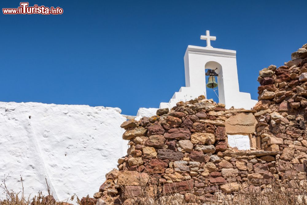 Immagine Architettura religiosa in un villaggio dell'isola di Kimolos, Grecia: particolare di un campanile con croce e campana.